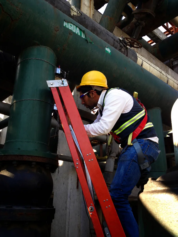 Inspección en una línea de agua industrial con arnés de seguridad